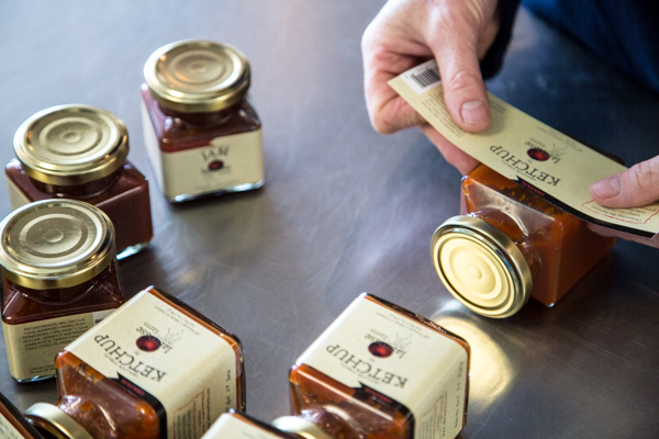 Dawn DeMuyt of Labrosse Farms labels jars of ketchup