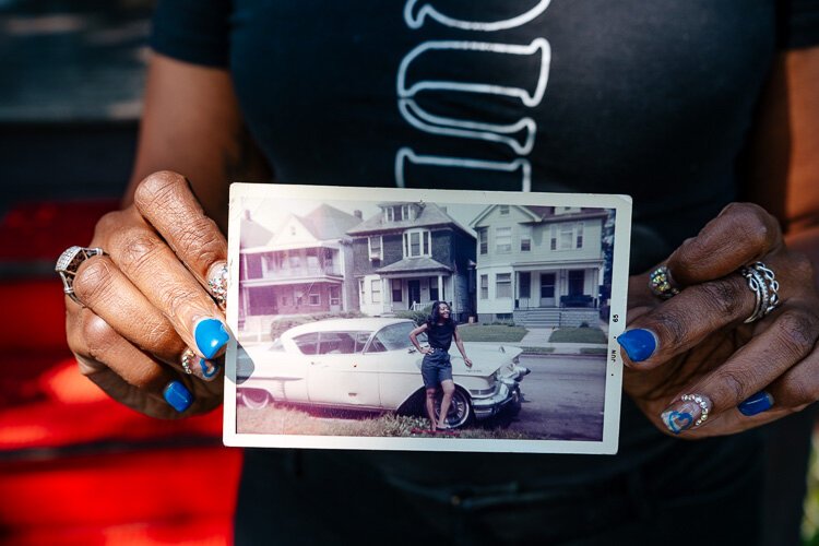 Jeanine holds a photo of her grandmother in front of her house in 1965.