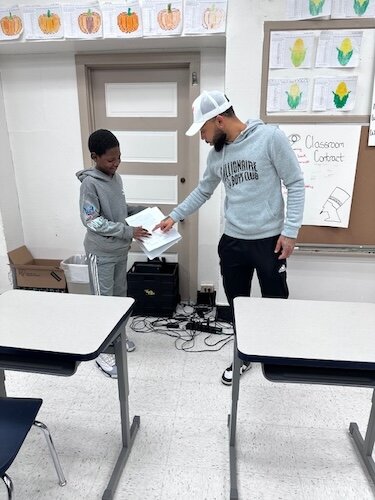 Kaypree Taylor, una empleada de R.I.S.E., trabaja con un joven en sus habilidades de lectura y asiste a otros jóvenes durante el tiempo de clase.