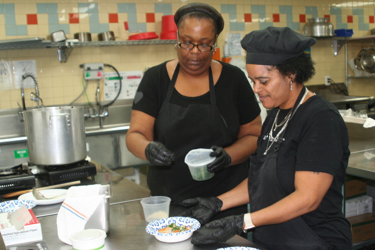 Joy Clark and Carmelina Capozzoli prepare lunch in Zaman International's training kitchen