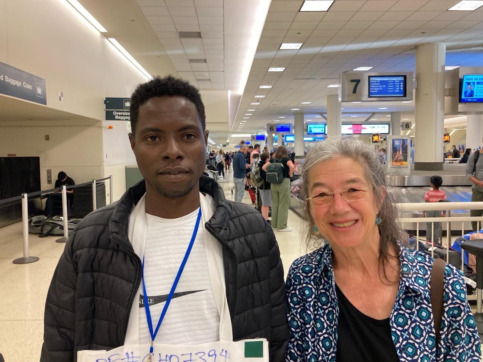 Newcomer Mohammed arriving at the airport to a welcome from Ruth, a member of the Cassopolis, Mich., private sponsor group that worked with Zaman during the 90-day resettlement period 