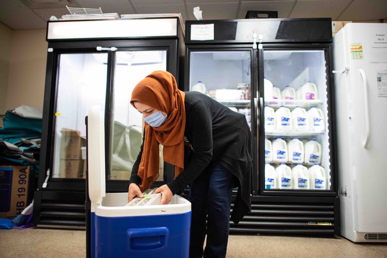 A volunteer puts away food at Jewish Family Services of Washtenaw County