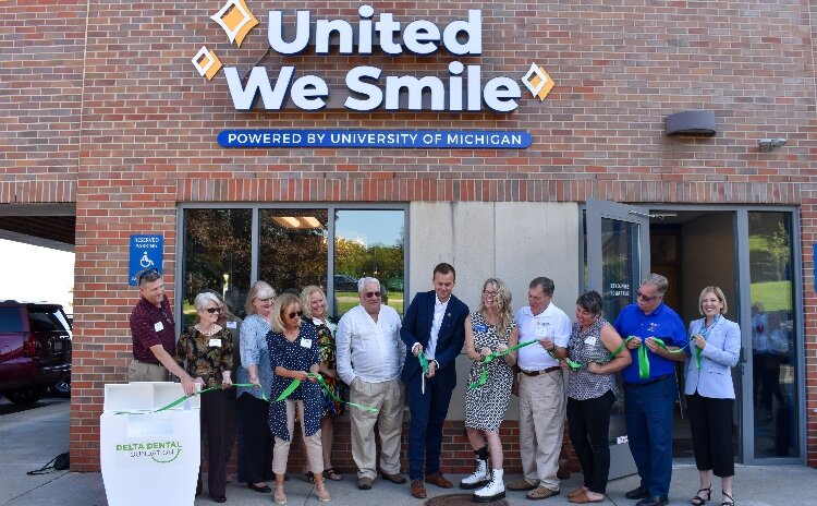 The United We Smile team celebrates together as they "cut the floss" to mark the clinic's grand opening in Traverse City.